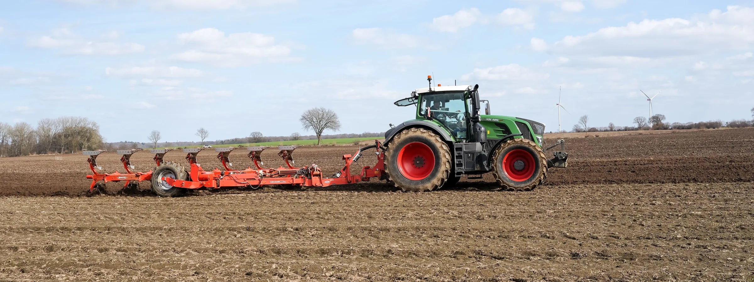 Traktor mit Pflug bei der Arbeit auf dem Acker im Herbst