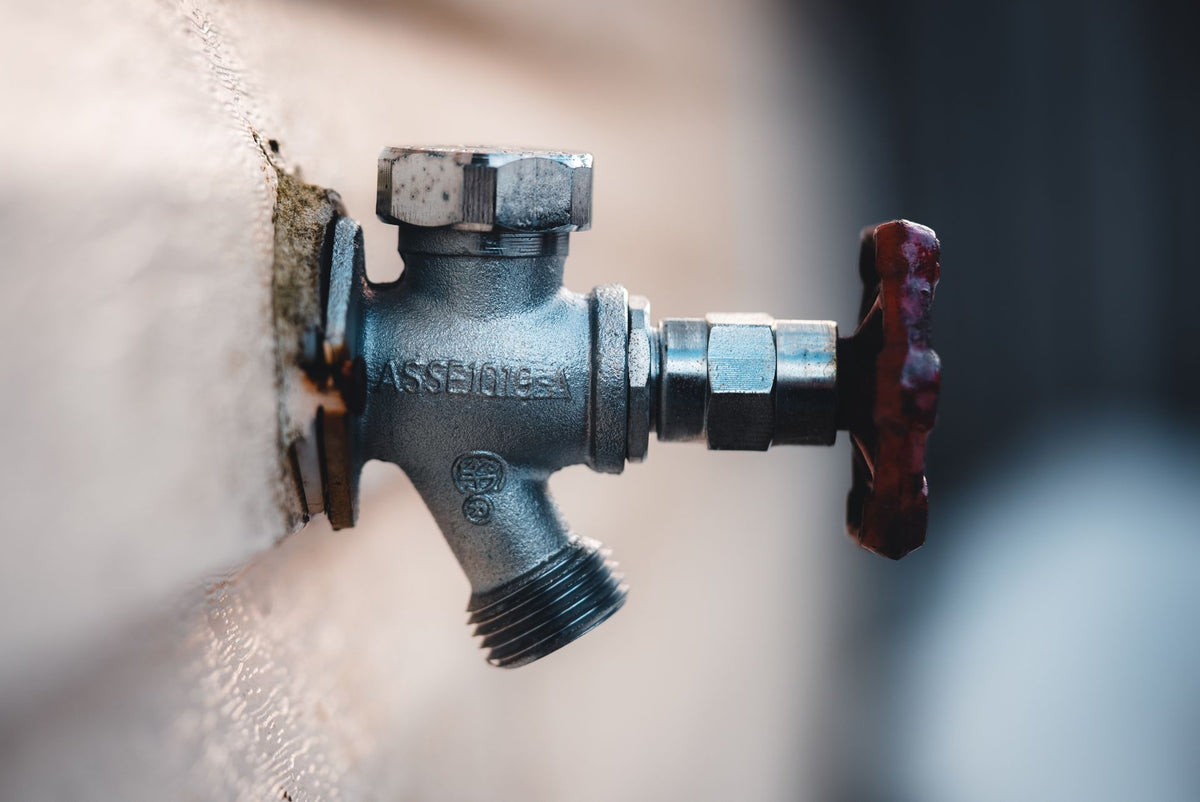 Metalen kraan aan een buitenmuur, voor buiteninstallaties en leidingwerk
