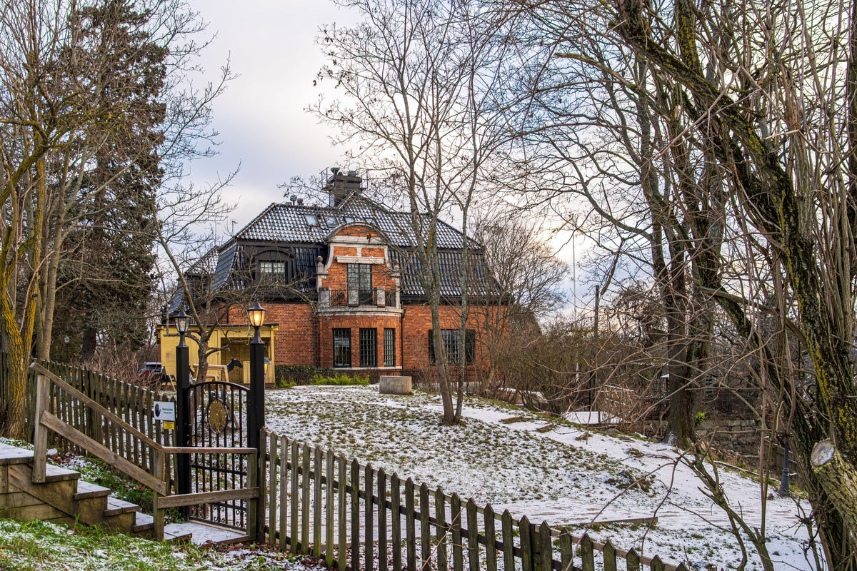 Sneeuwbedekte tuin bij rood bakstenen huis in de winter