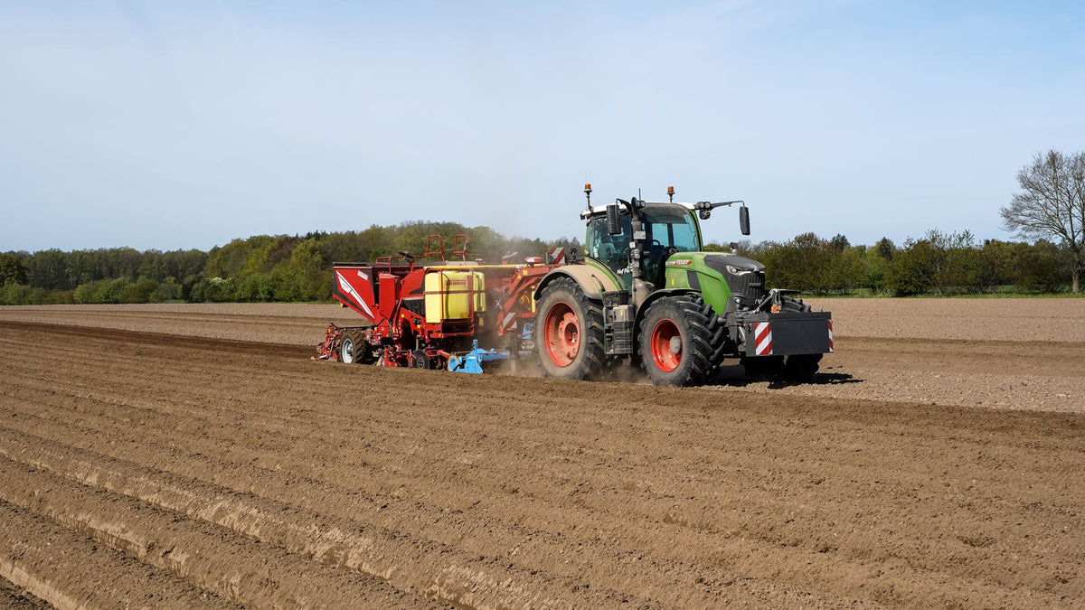 Trekker met aardappelwerktuig op een Duits akkerbouwperceel