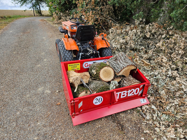 GeoTech Pro TB120 transportbak voor de trekker, met een lading boomstammen langs het pad (foto van een gebruiker)